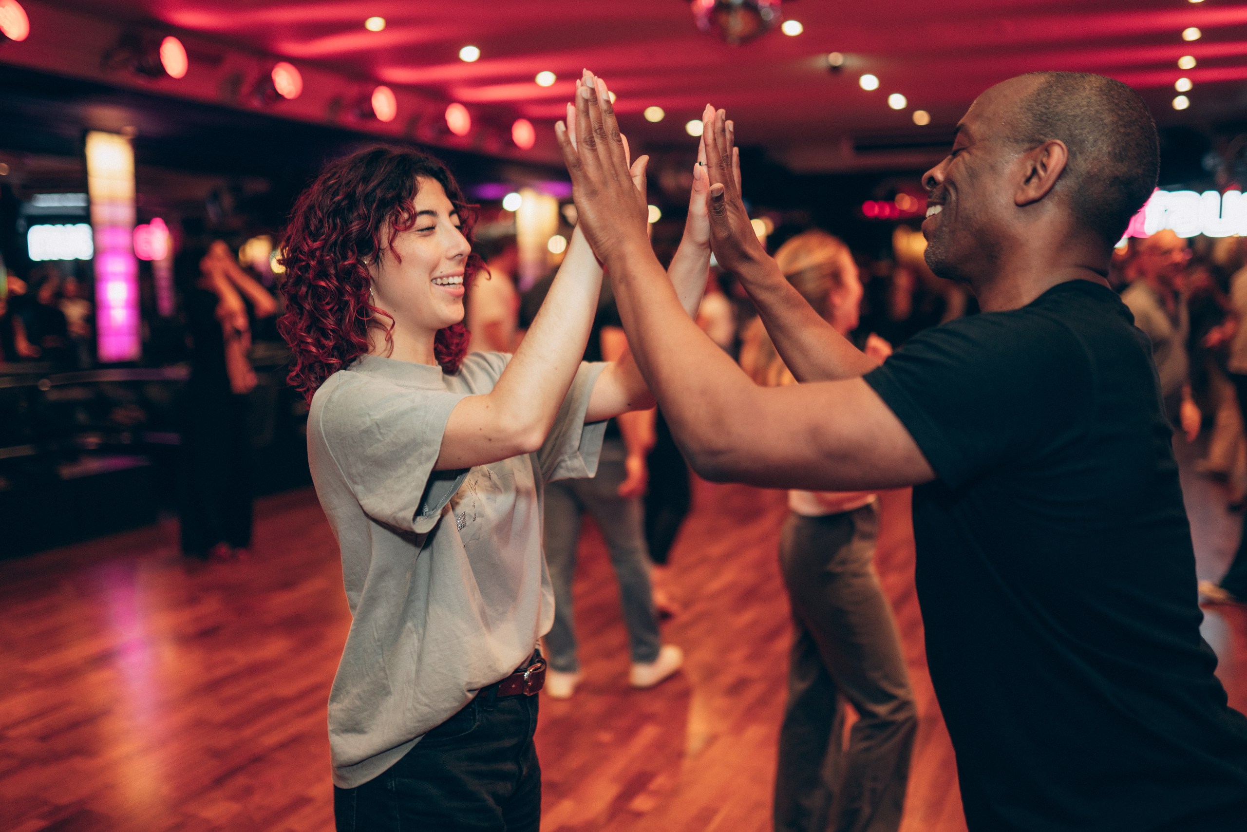 Zwei Menschen klatschen ab während eines Salsa-Unterrichts in einer Tanzschule in Köln