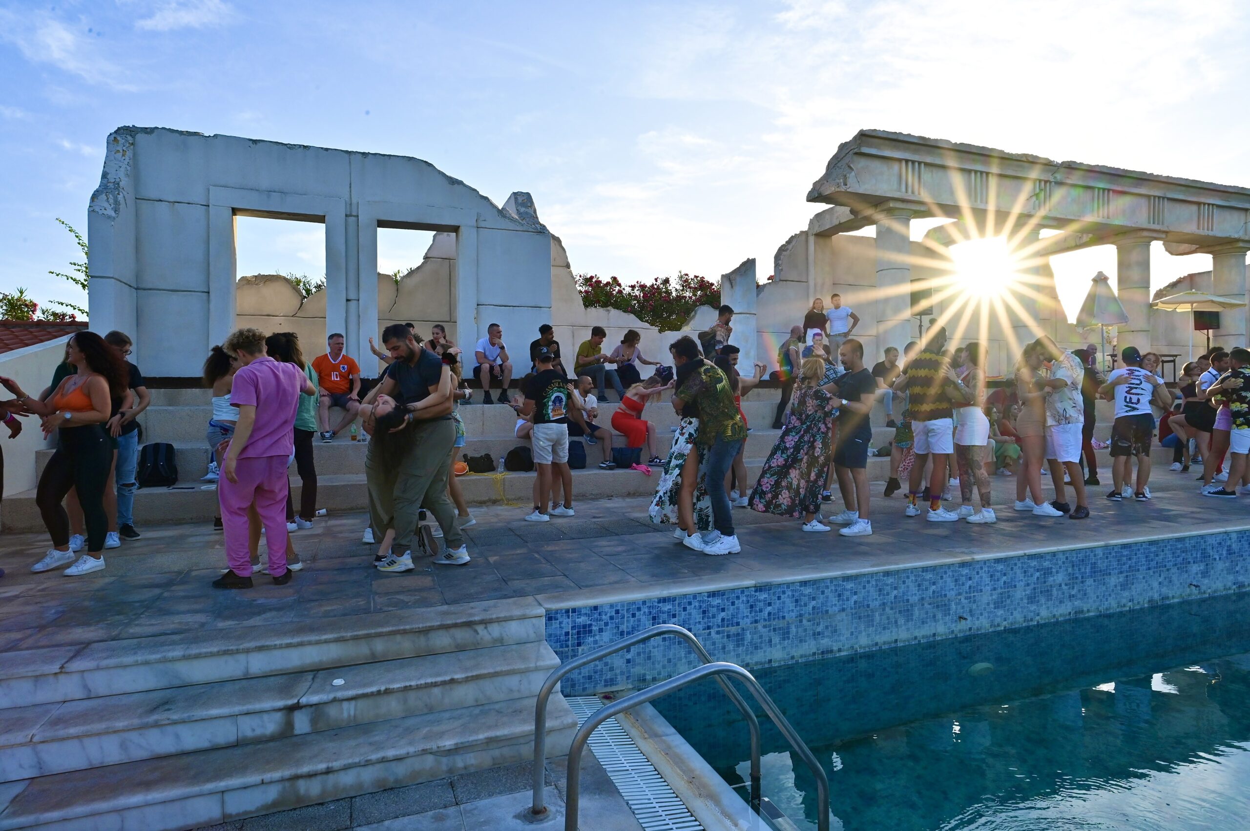 Eine Gruppe von Menschen, die in der Nähe eines Schwimmbeckens auf einer Bachata-Party Bachata tanzen