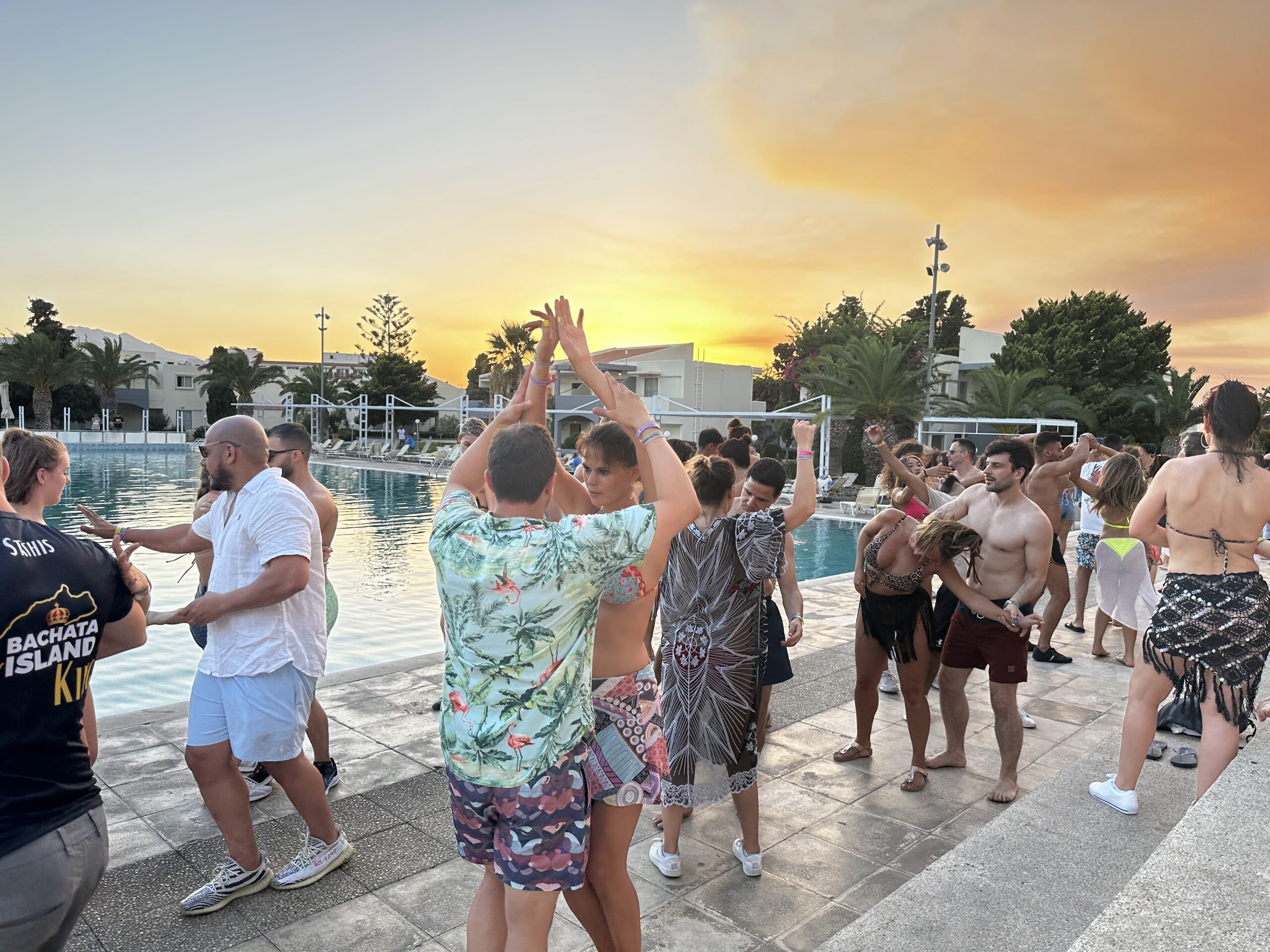 Eine Gruppe von Menschen, die bei Sonnenuntergang auf einer Bachata-Party Bachata tanzen